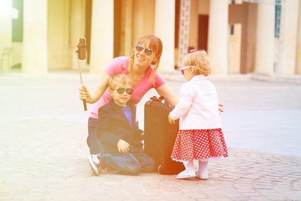 mother and kids taking selfie stick picture in Europe