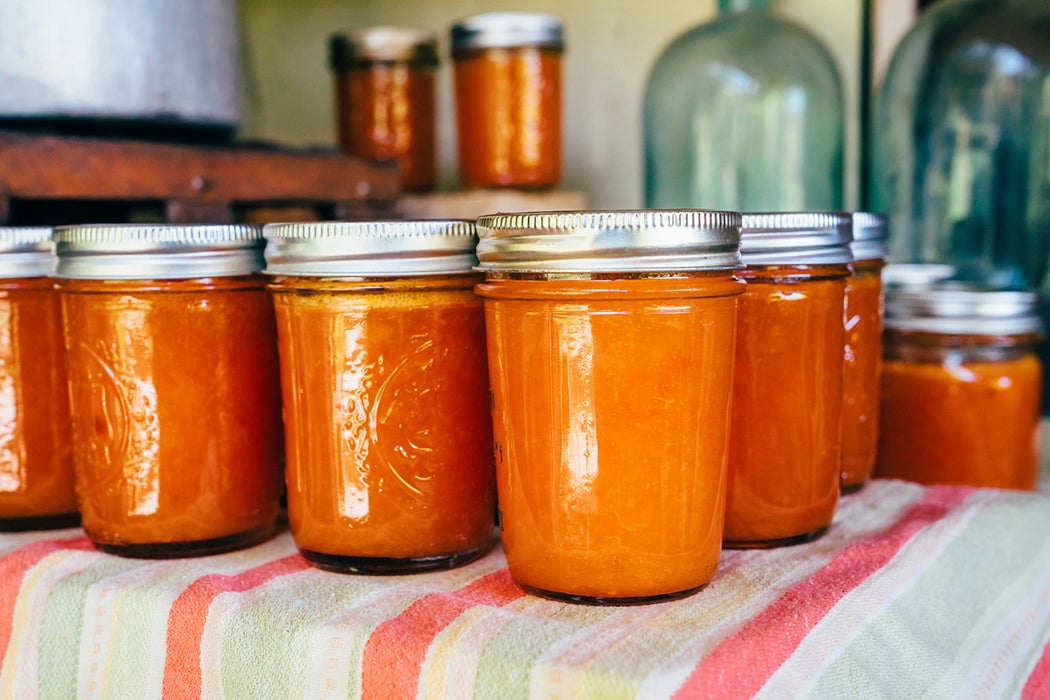 Jars of peach jam on table