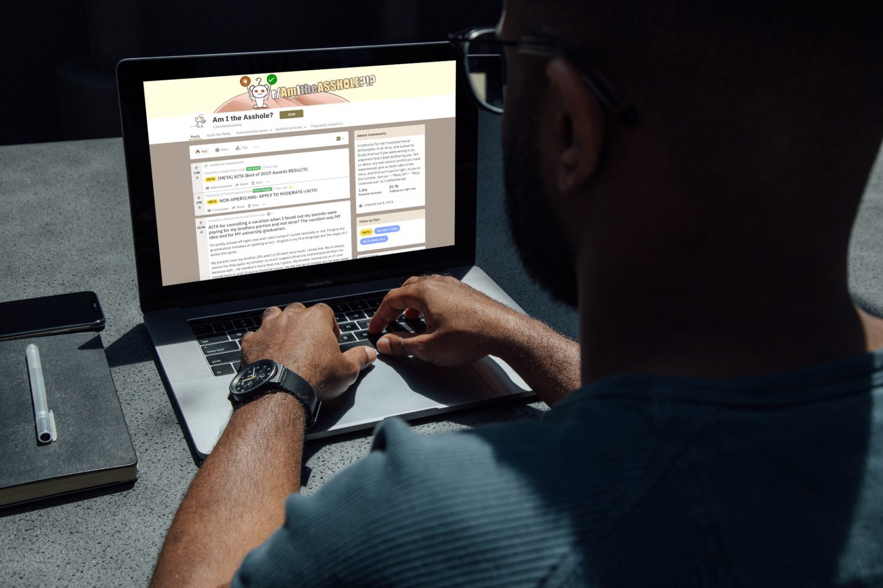 A man looking at Reddit on a laptop