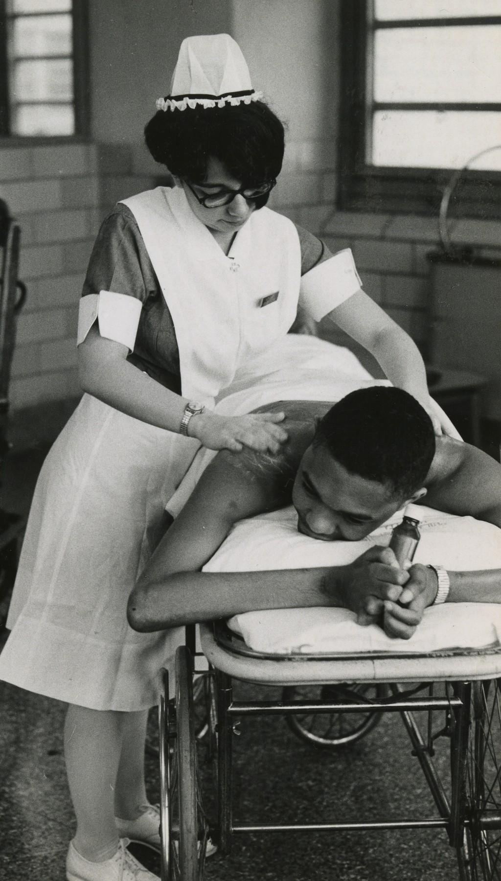 A student nurse tends to a patient, c. 1954