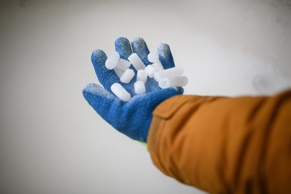 A hand holding coarse dry ice pellets