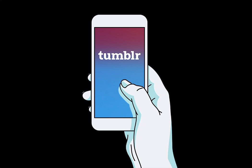 A hand holding a smartphone with a tumblr logo