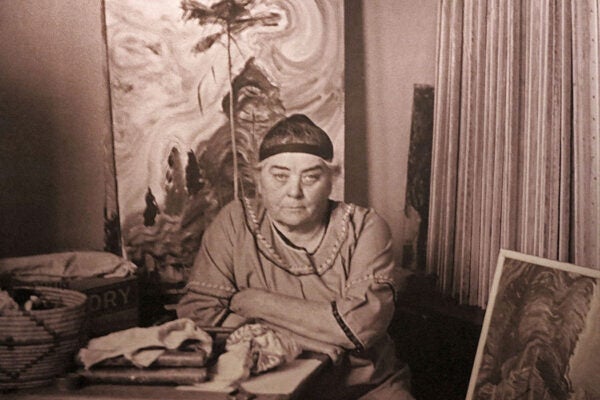 Emily Carr in her studio with the painting Sunshine and Tumult, c. 1939.