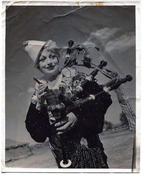 Publicity photograph of Lulu Adams in clown costume with bagpipes.